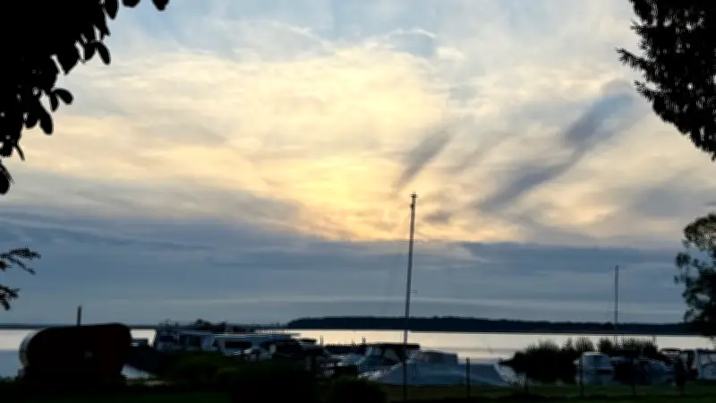 Wolkengemälde am Himmel über Röbel: Mystischer Sonnenaufgang am Hafen
